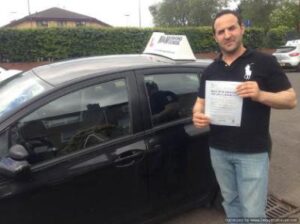 Pass Your Test and Find the Right Car: Manual vs. Automatic Person holding certificate by car.