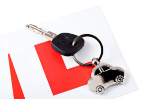 A keychain with a silver car and one key on white background